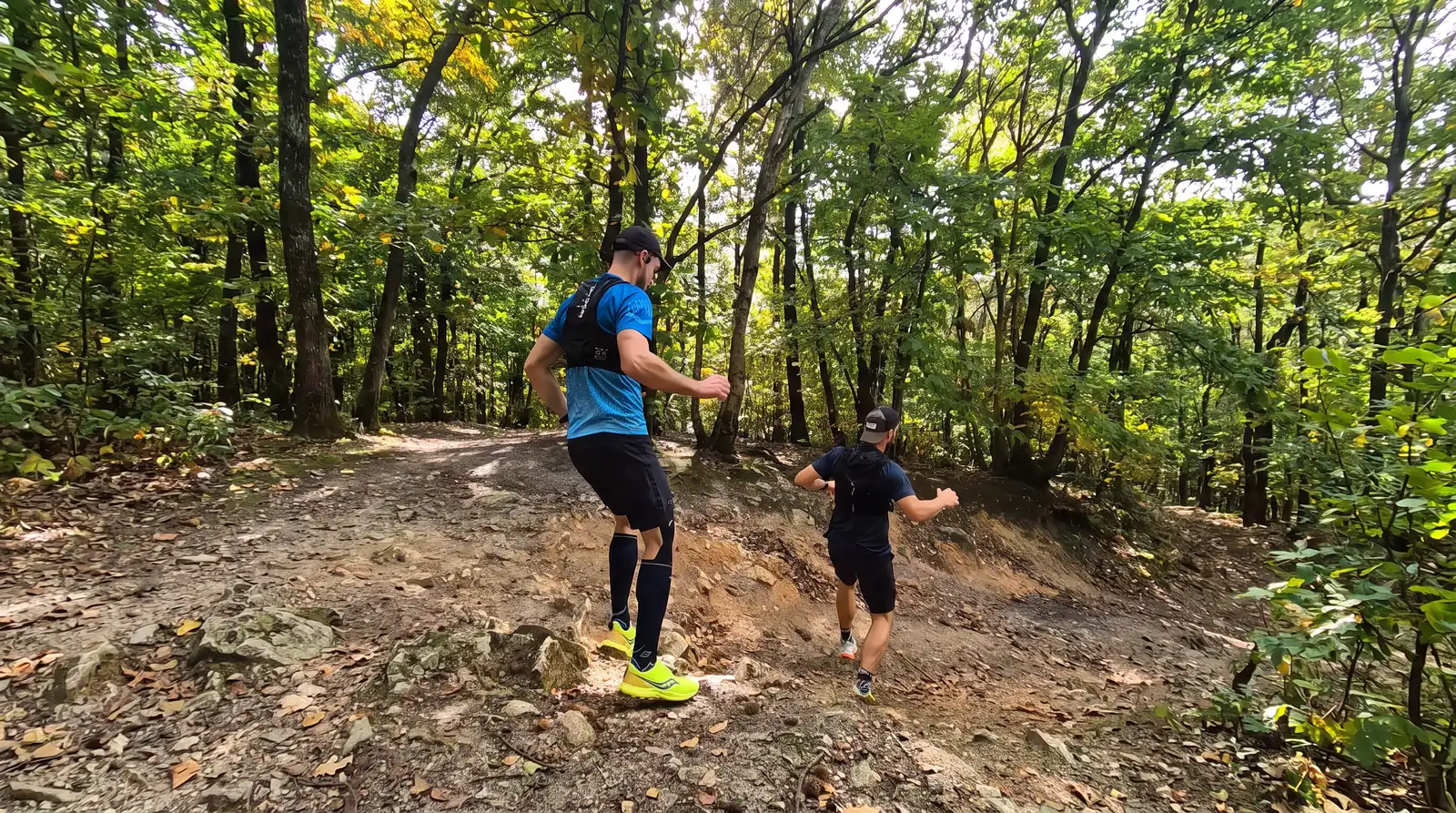 Deux coureurs en montée sur un sentier forestier